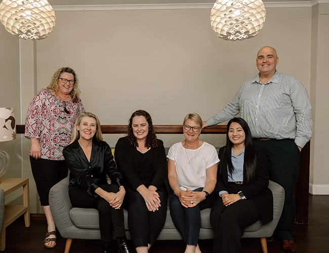 The team at Pearce Martin sitting on a lounge in their office